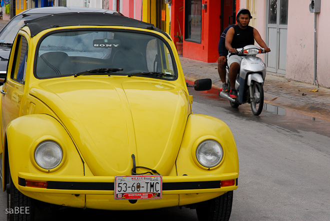 yellow vw and a scooter in Mexico