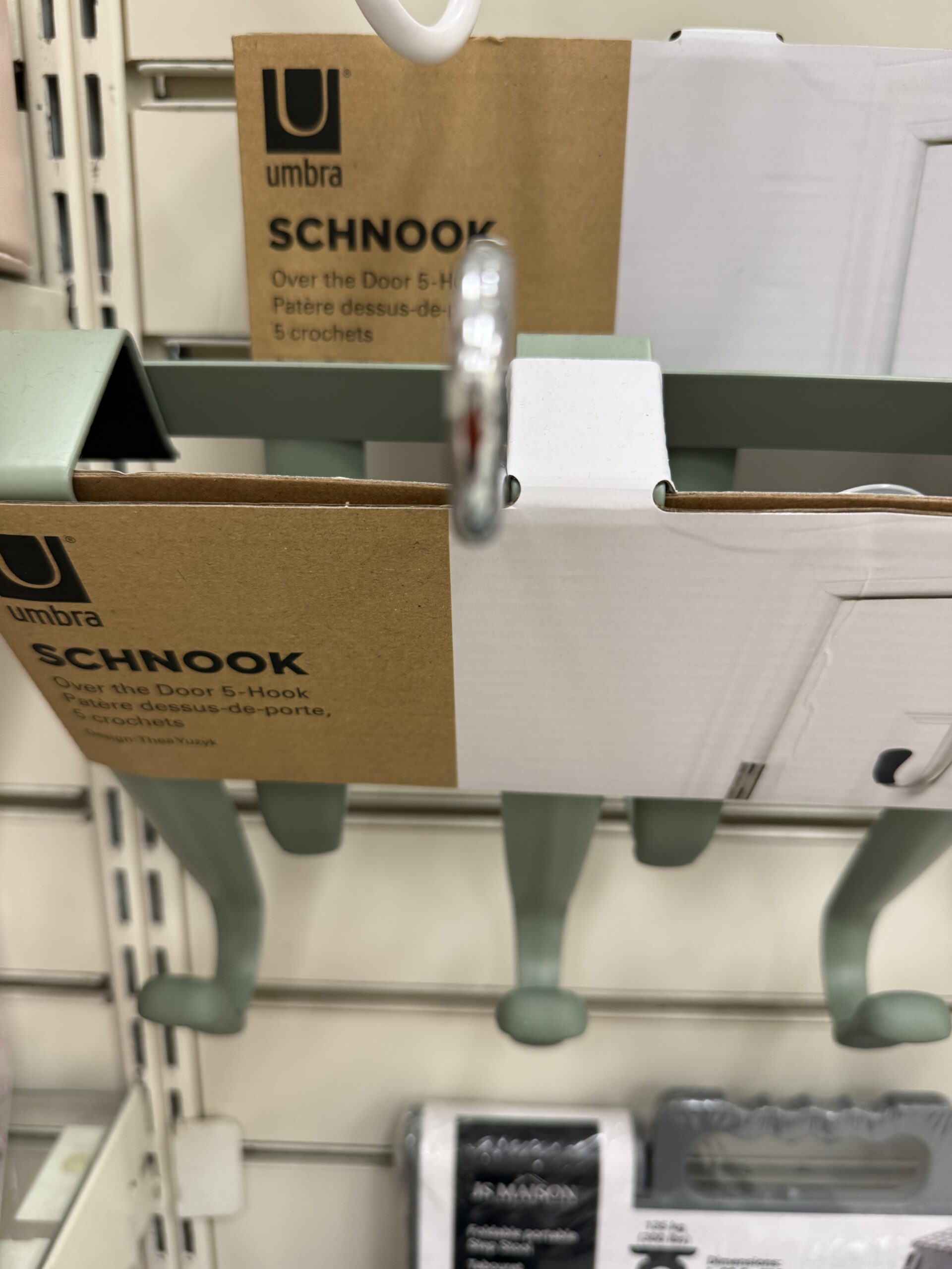 Umbra Schnook over-the-door 5 hook organizers in sage green on a store display shelf